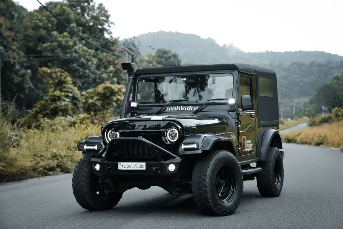 A black jeep driving down a rural road